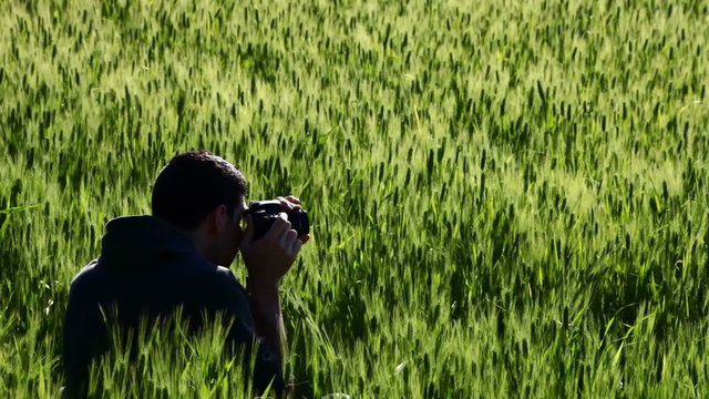 A photographer in a field of wheat