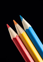 Naklejka premium Blue, Yellow and Red Pencils on Black Background