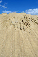 Brown sand mound against blue sky