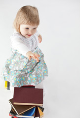 Little girl playing among books