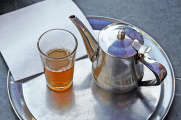 A kettle of moroccan mint tea and a glass