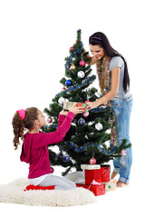 Mother and daughter near a christmas tree with gifts on a white 