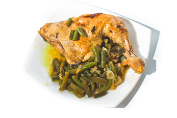 Fried chicken leg with french beans on white plate.