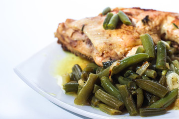 Fried chicken leg with french beans on white plate.