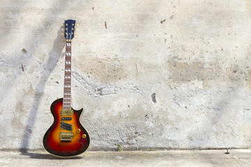 electric guitar in front of a vintage wall - obrazy, fototapety, plakaty