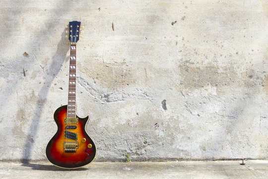electric guitar in front of a vintage wall © alexandre zveiger