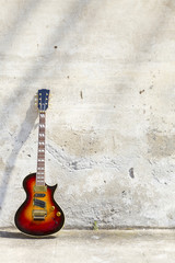 Fototapeta na wymiar gitara elektryczna z przodu z rocznika ścianie