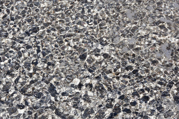 Textur von Meerwasser durch das der Sand durchscheint