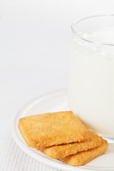 Glass of milk on the plate with cookies on the side