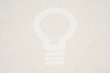 Bulb light icon on sand background and textured