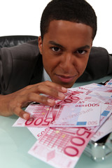 Young businessman with a pile of cash