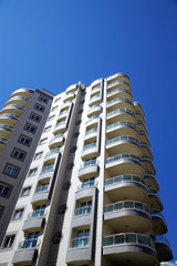 Fototapeta na wymiar wysokiej nowoczesny budynek mieszkalny na tle niebieskiego nieba