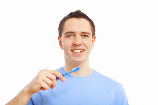 Young man at home brushing teeth