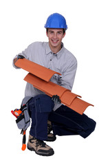 Worker holding roof shingles