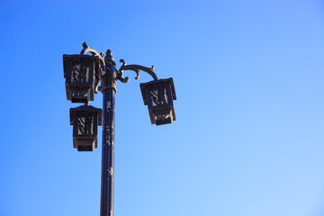 Retro-styled streetlight under blue sky at sunrise