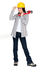 A female construction worker holding a wrench.