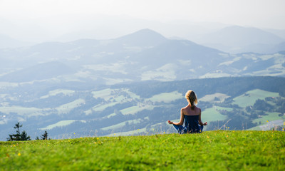 Young woman meditating outdoors - obrazy, fototapety, plakaty