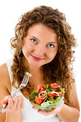 Young woman eating vegetable salad isolated on white background
