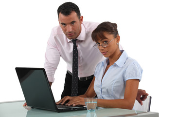 Serious working couple using a laptop