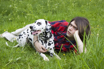 boy and the dalmatian dog on the grass - obrazy, fototapety, plakaty