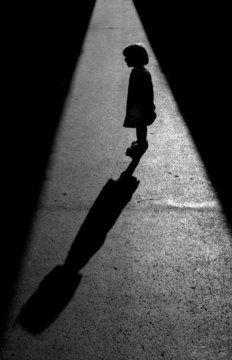 Silhuete of a little girl talking to her shadow