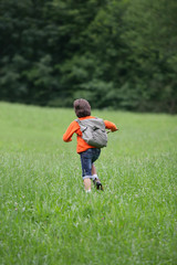 Fototapeta premium Boy running through the grass
