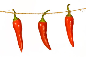 three chili peppers on a rope