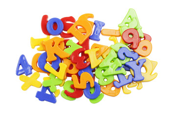 Plastic alphabet letters stacked on a white background