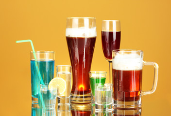 a variety of alcoholic drinks on yellow background