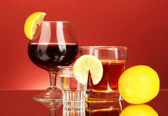 a variety of alcoholic drinks on red background