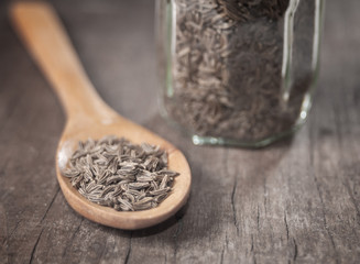 Indian cumin seeds in a spoon on table