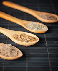 various spices in wooden spoons