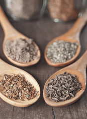 various spices in wooden spoons