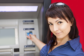 Fototapeta na wymiar Woman withdrawing money from credit card at ATM