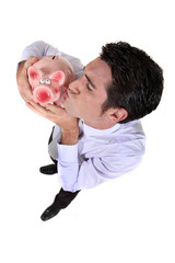 Businessman kissing a piggy bank