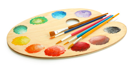 wooden art palette with paint and brushes isolated on white
