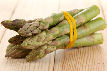 Useful asparagus close-up on wooden table on white background