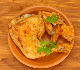 roasted chicken wings and leg with parsley in the plate