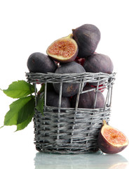 Ripe sweet figs with leaves in basket isolated on white