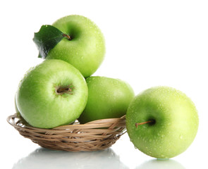 Ripe green apples with leaves in basket isolated on white