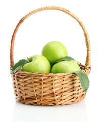 Ripe green apples with leaves in basket isolated on white