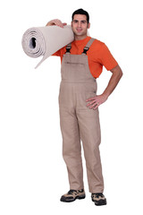 Man holding a roll of carpet