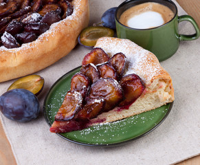 fresh baked plum pie on plate with cup of cafe