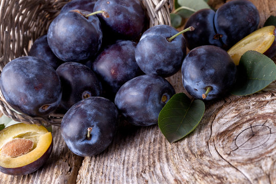 plums scattered on wooden background