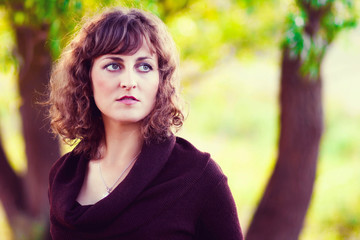 curly-haired woman young European girl curled in brown dress a l