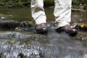 Wanderer kühlt seine Füsse im Bach