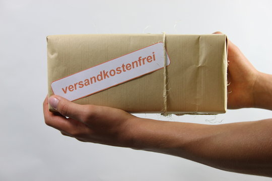 Mann hält versandkostenfreies Paket