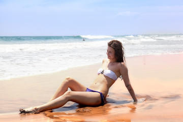 beautiful girl sunbathes on an ocean coast