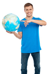 Smart guy pointing at the globe. Dressed in casuals