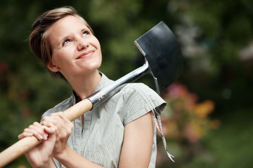 lovely young woman, portrait in the garden with spade